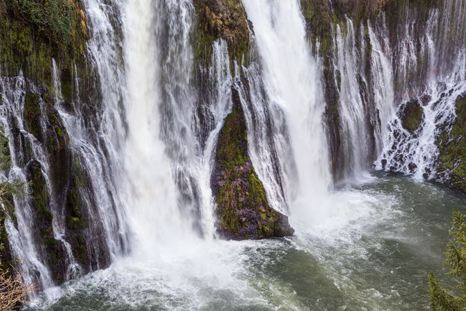 Large waterfalls cascading down mossy cliffs