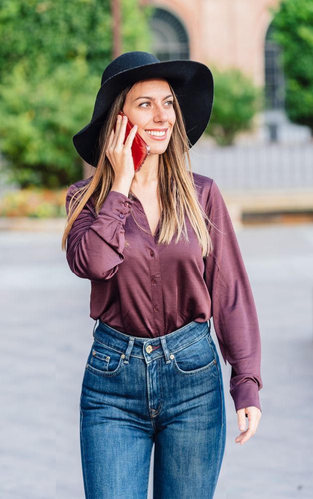 Woman in trendy outfit talking on smartphone
