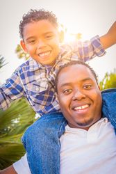 Son and Father Playing Piggyback Outdoors Together.