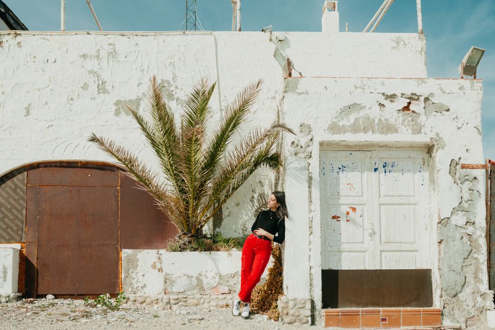 Woman relaxing near weathered house
