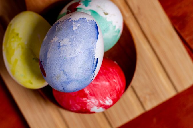 Set of painted Easter eggs in container on table