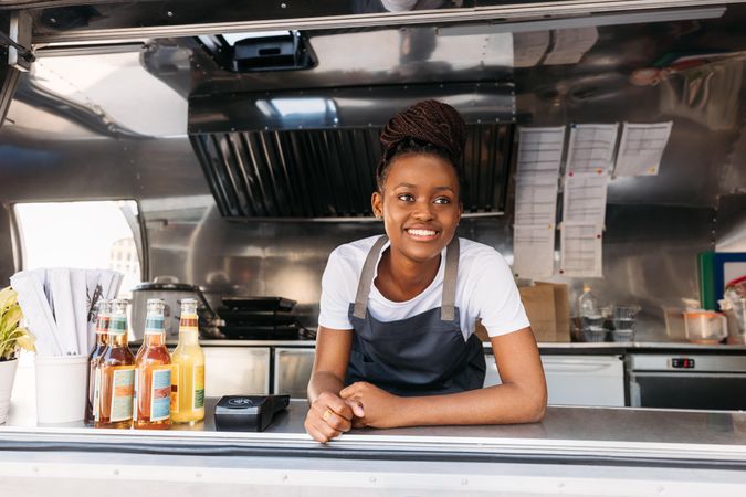 Happy female server smiling in food truck window