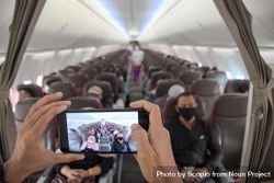 Person taking a photo of airplane passengers with facemasks 5Qkwgb
