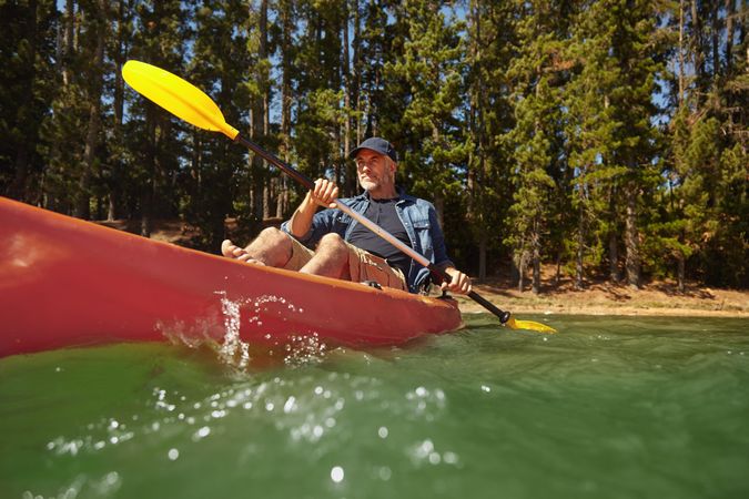 Portrait of mature man paddling a kayak in a lake