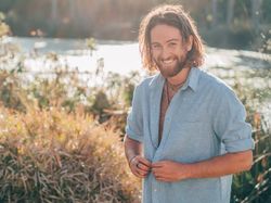Hipster man unbuttoning shirt to go swimming
