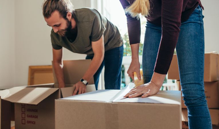 Couple packing their household articles in packing boxes