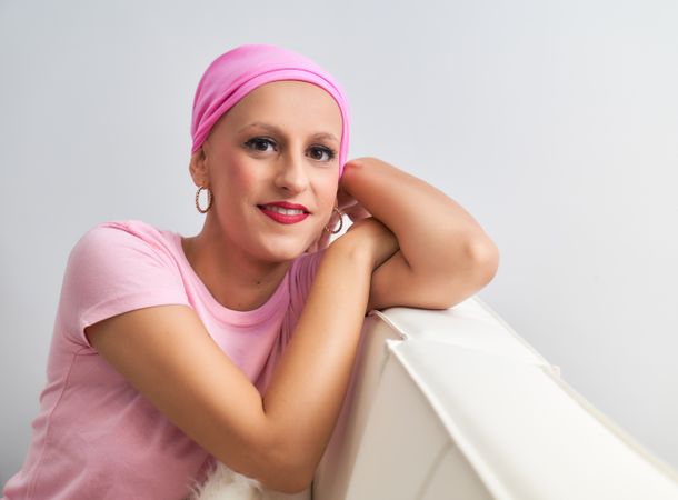 portrait of a woman suffering from breast cancer with pink handkerchief resting her chin on her hand