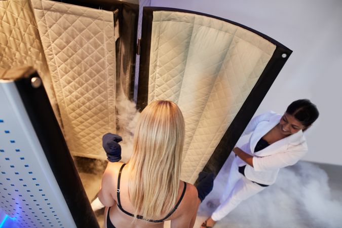 Technician with client going into cryotherapy chamber