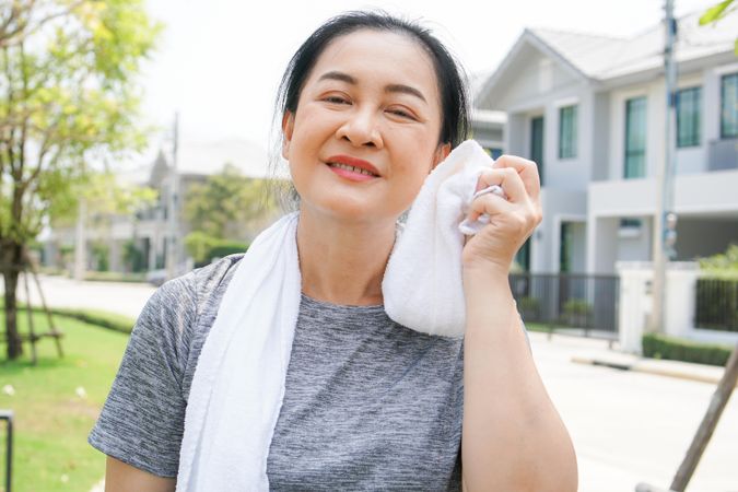 Woman with towel wiping face after workout