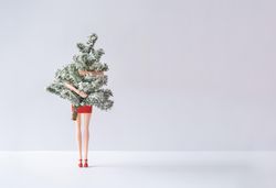 Barbie like doll in red dress holding Christmas tree hiding half of body