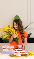 Girl in orange dress holding yellow flowers