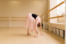 Ballet dancer bending forward in pink tutu