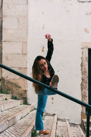 Casual woman dancing on old city street