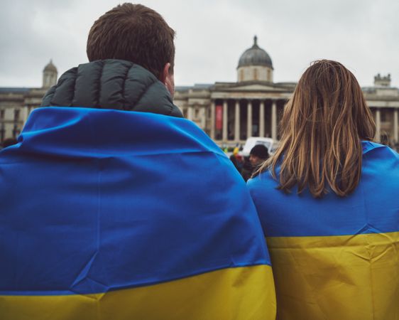 London, England, United Kingdom - March 5 2022: Man and woman draped in Ukrainian flag at protest