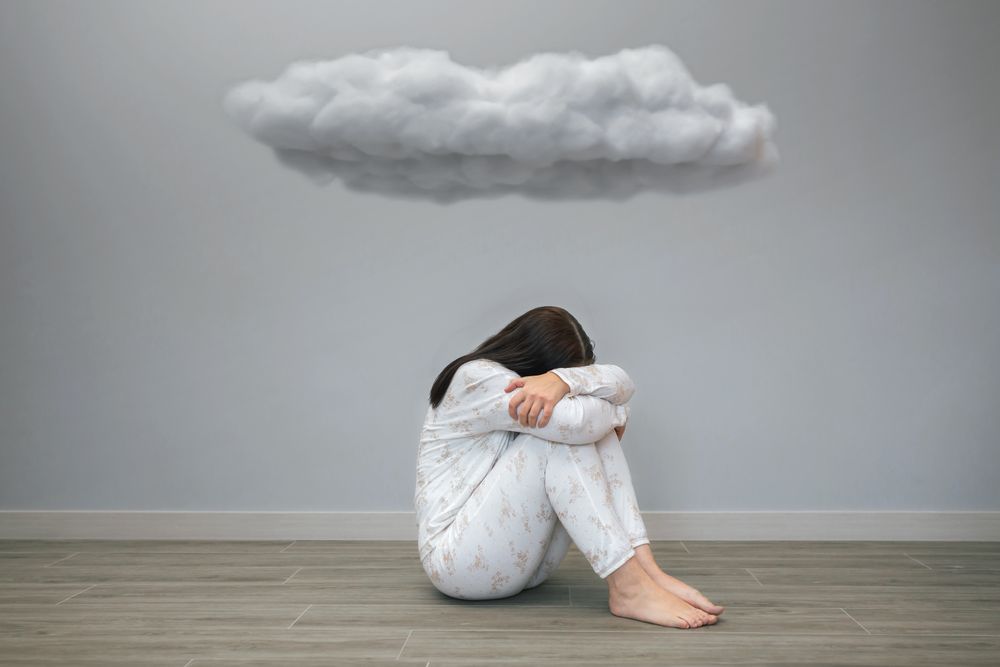 Woman with sad thoughts crying under a dark cloud