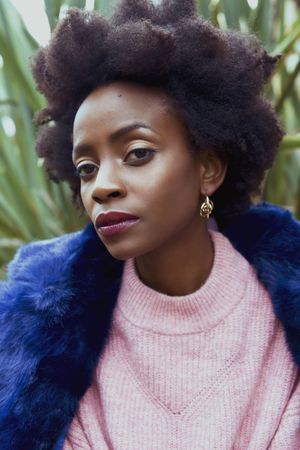 Black woman in pink top blue fur jacket
