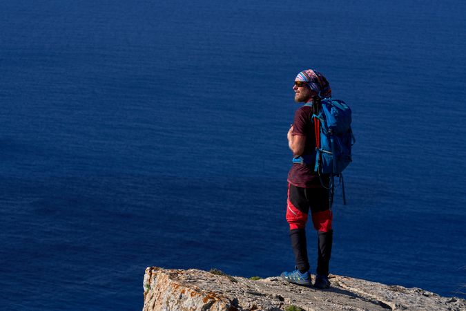 Man with backpack standing on cliff