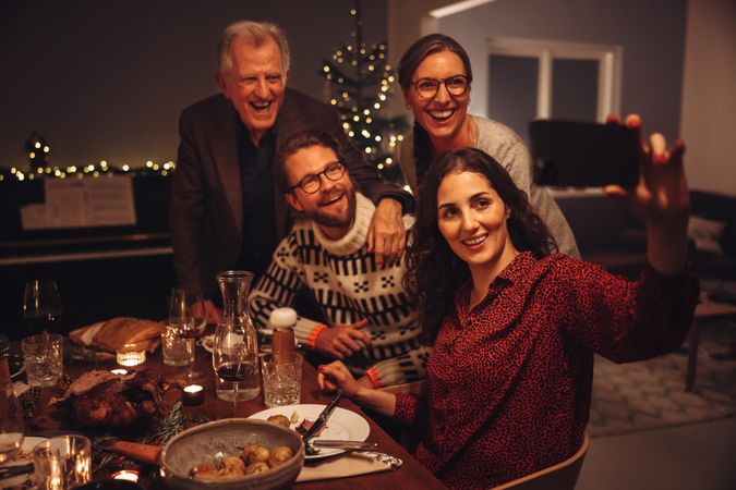 Woman taking selfie with family during thanksgiving dinner