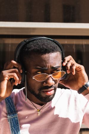 Stylish Black man listening to music in headphones