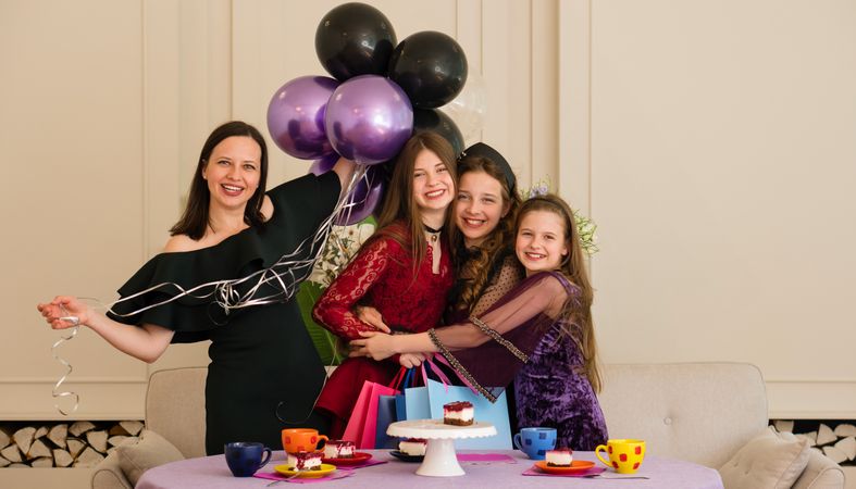 Teen with woman and two young girls. Birthday Party
