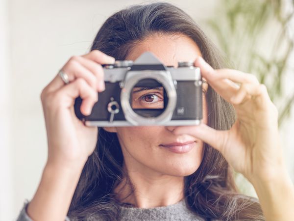 Content woman with retro film camera