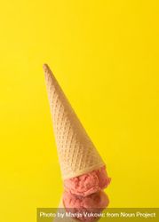 Upside-down cone with pink scoop of ice cream on yellow background 5RRWW5