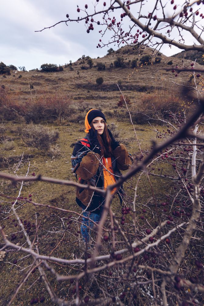 Hiker with backpack standing along pathway in autumn forest