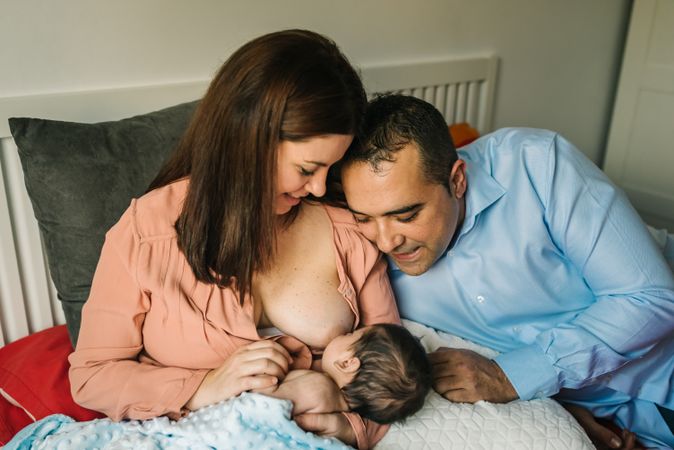 Mom near father breastfeeding at home