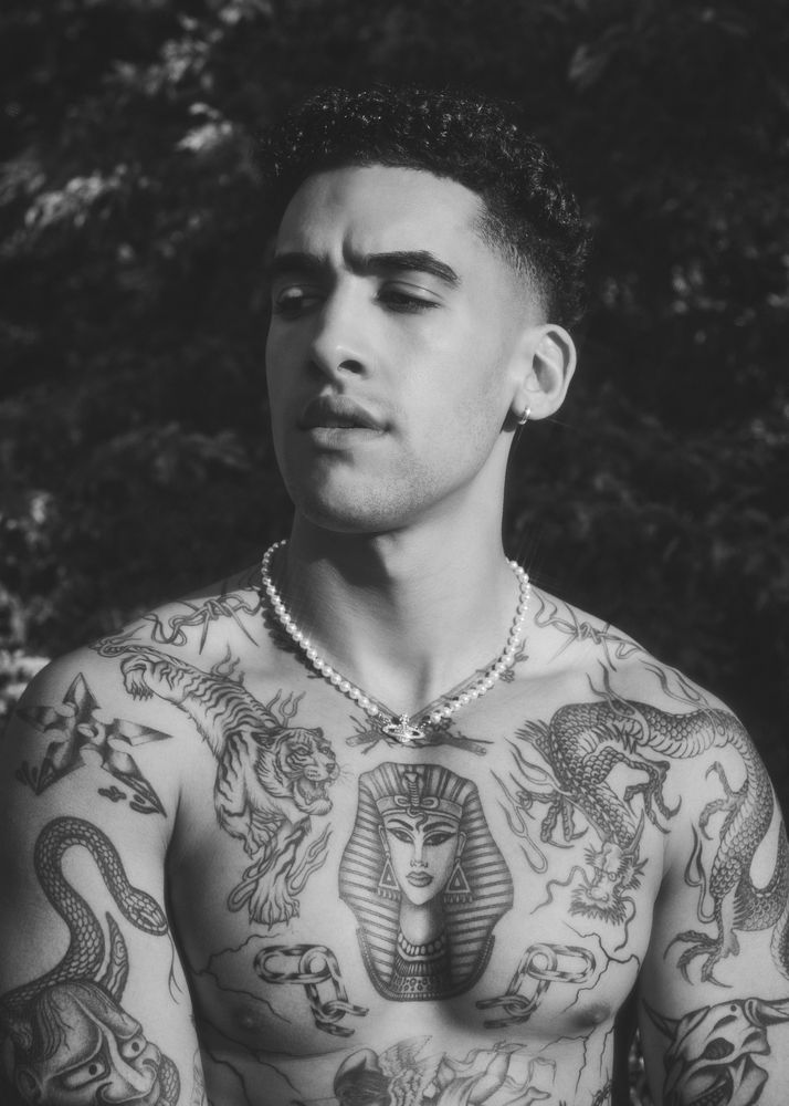 B&W portrait of tattooed shirtless male with eyes closed