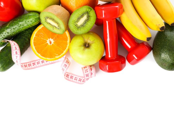 Dumbbells, measuring tape and fruits isolated on plain background