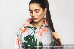 Beautiful woman in ponytail pictured in colorful printed floral hoodie with her eyes closed 41N3Lb