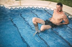 Man lying on steps in pool