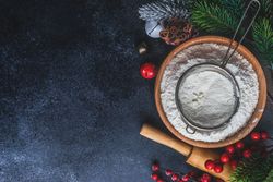 Top view of flour with sieve for Christmas baking on counter with copy space