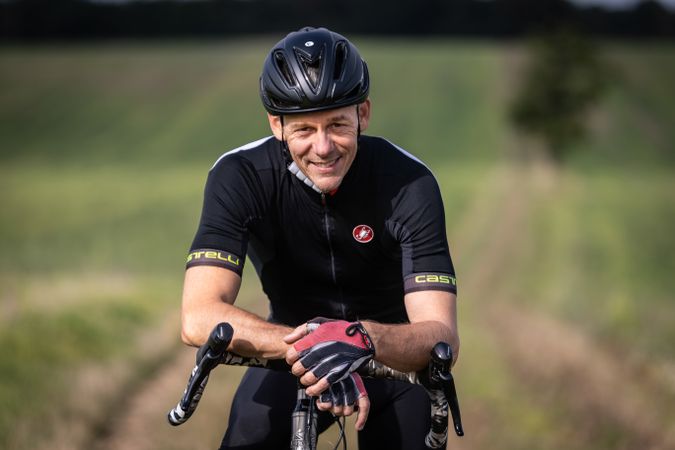 Portrait of man riding bicycle in field