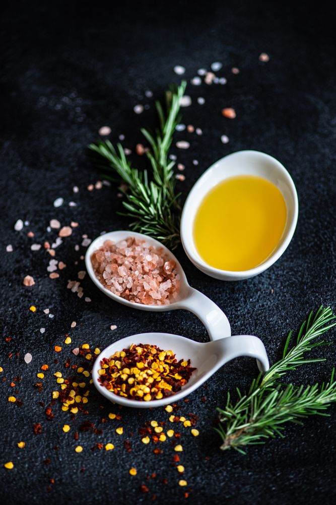 Close up of chilli flakes, oil, rosemary and salt