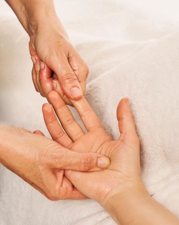 therapist massaging a woman's hands. Decontracting hand massage