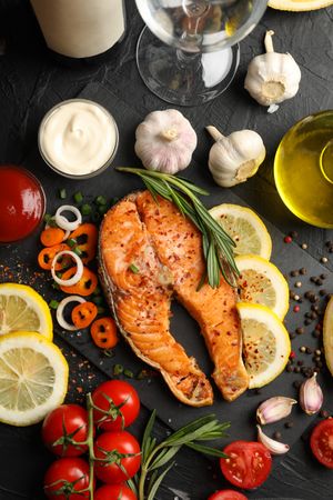 Composition with tasty grilled salmon on dark background, top view