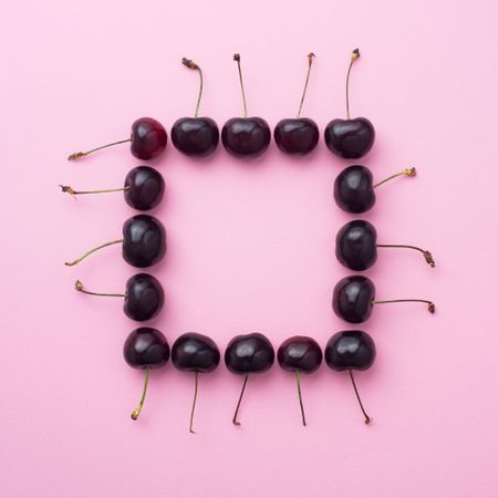 Cherries in a square shape on pink background