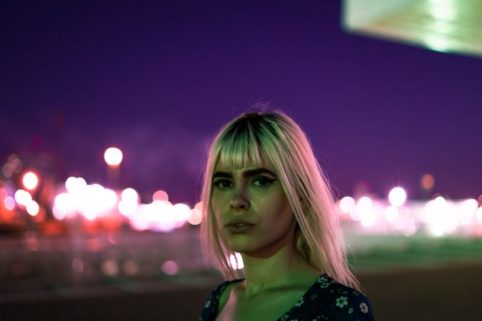 woman looking at camera against vibrant sky at dusk