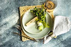 Easter concept with branch and green decorative eggs on ceramic plates