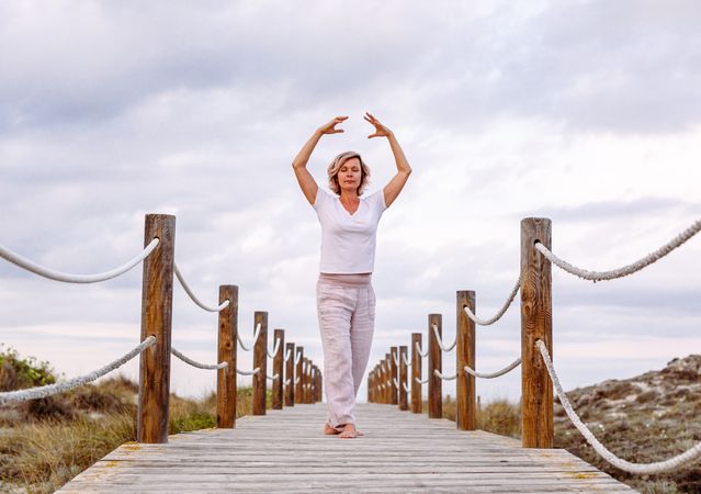 Barefoot woman exercising on wooden path