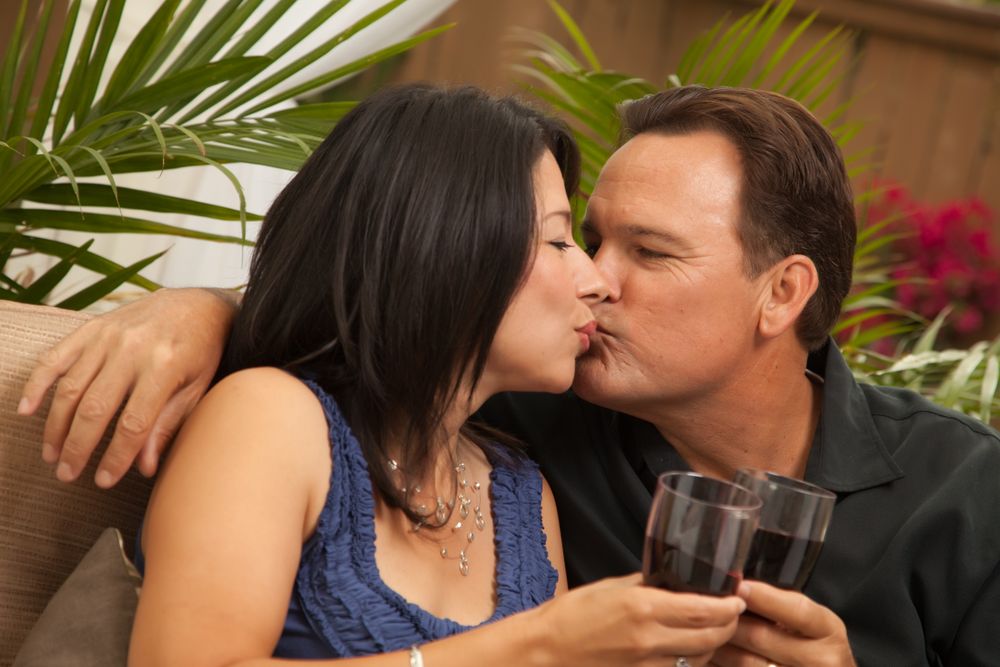Interracial Couple Drinking Wine and Kissing