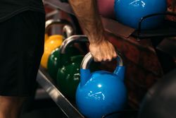 hand of a man taking a kettlebell
