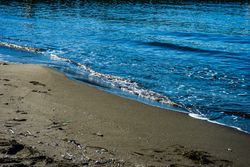 Dark volcanic sand beach and sea
