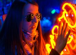 Stylish young woman near illuminated board