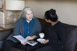 Happy women reading a magazine at home together