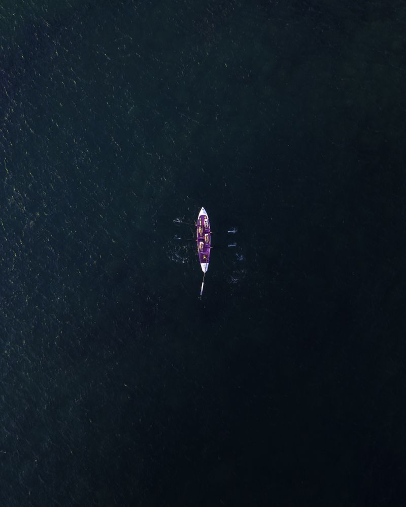 Aerial view of people paddling row boat in sea