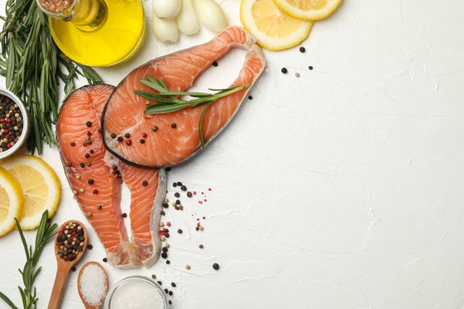 Composition with salmon meat and spices on plain background, top view