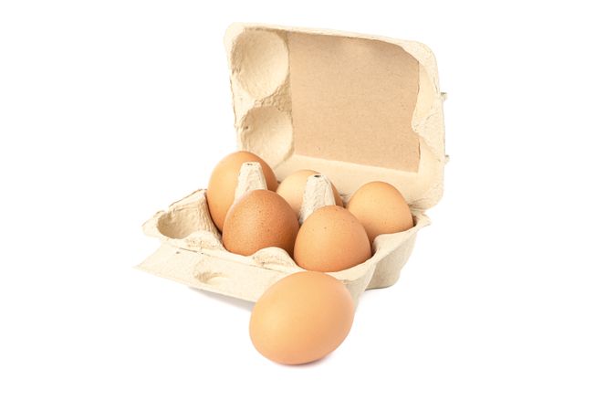 Brown chicken eggs in carton box isolated on light background