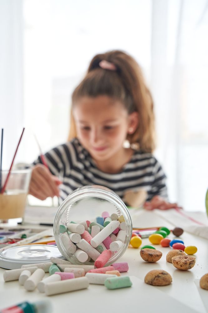 Crayons on table near girl